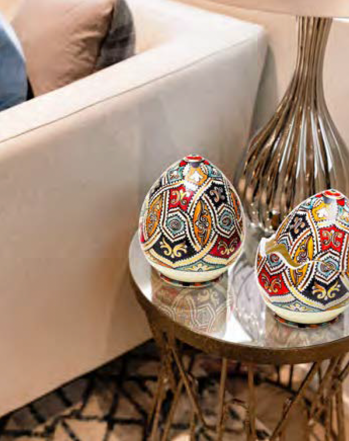 Decorative eggs with intricate patterns on a small round table in a living room setting.