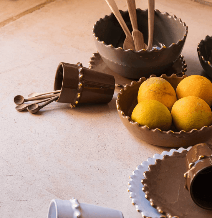 handmade green ceramic serving bowl with gold trim styled on dining table