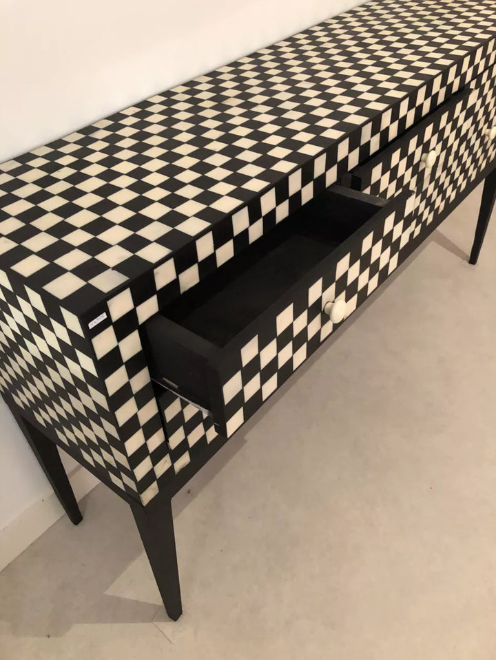 Black and white checkered patterned console table with a drawer.