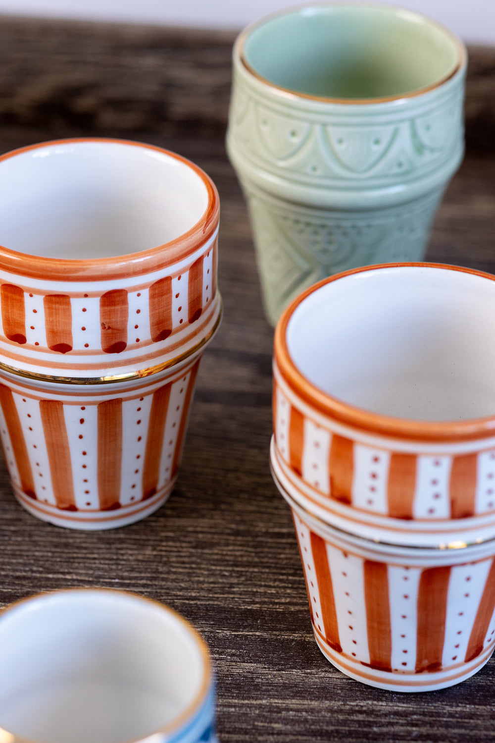 Set of ceramic pots with striped patterns on a wooden surface