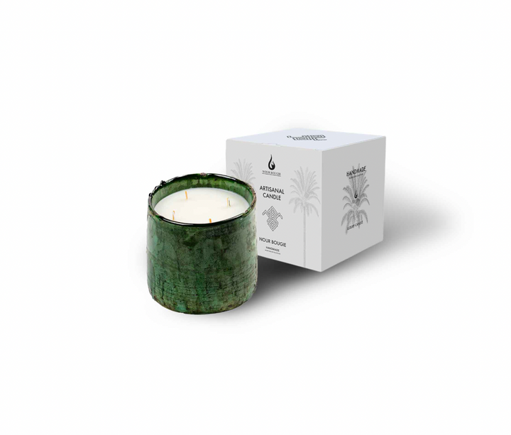 Green candle with decorative packaging on a white background