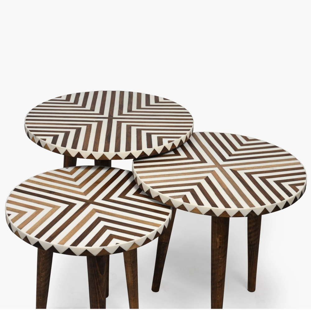Set of three round tables with geometric patterned tops on a white background